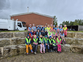 Gruppenfoto der Vorschulgruppe vor einem Betriebsgebäude mit LKW
