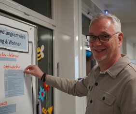Bürgermeister Harders heftet einen Zettel an eine Pinnwand