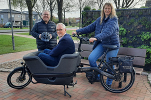Der Bürgermeister sitzt in der Ladefläche des Lastenrades, Heiko Tinnemeyer steht rechts und Nicole Beck steht am Fahrrad.