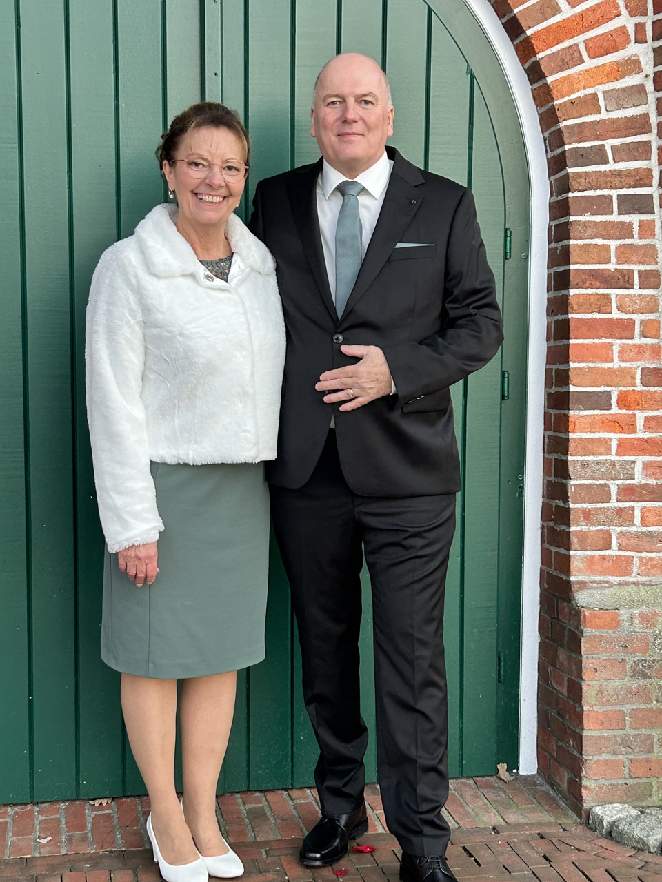 Ein Brautpaar steht vor dem Eingangstor der Mühle Idafehn