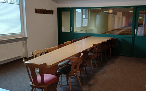 Kegelbahn mit Tischreihe und Stühlen im Vordergrund