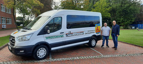 Hinten rechts neben einem weißem Ford Transit Transporter stehen Tourist-Mitarbeiter Heiko Tinnemeyer und Bürgermeister Günter Harders