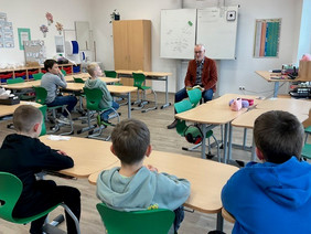 Bürgermeister Harders liest einer Schulklasse vor