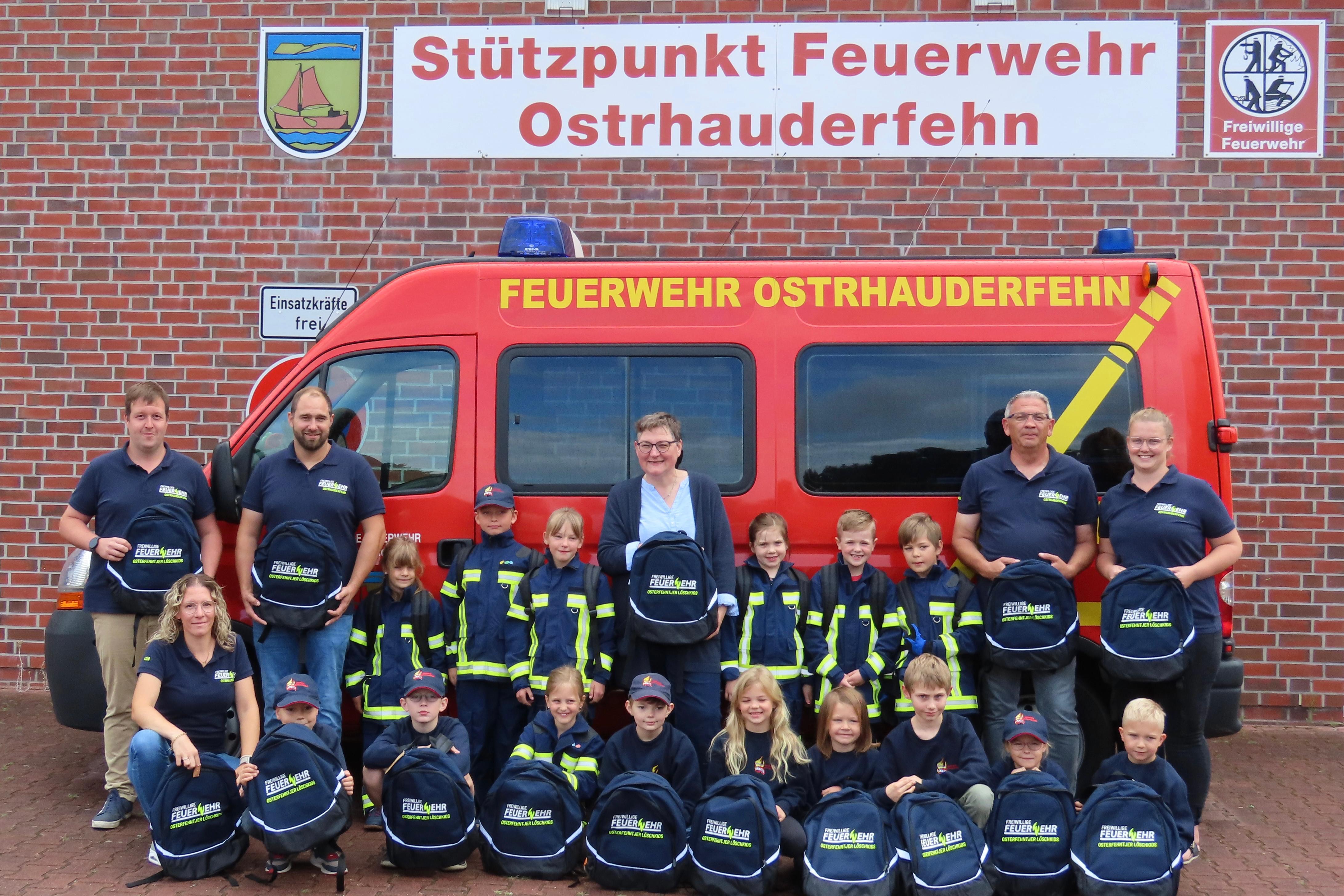 Gruppenfoto der Kinderfeuewehr mit Betreuern und Ute Kannegießer bei der Übergabe der Rücksäcke
