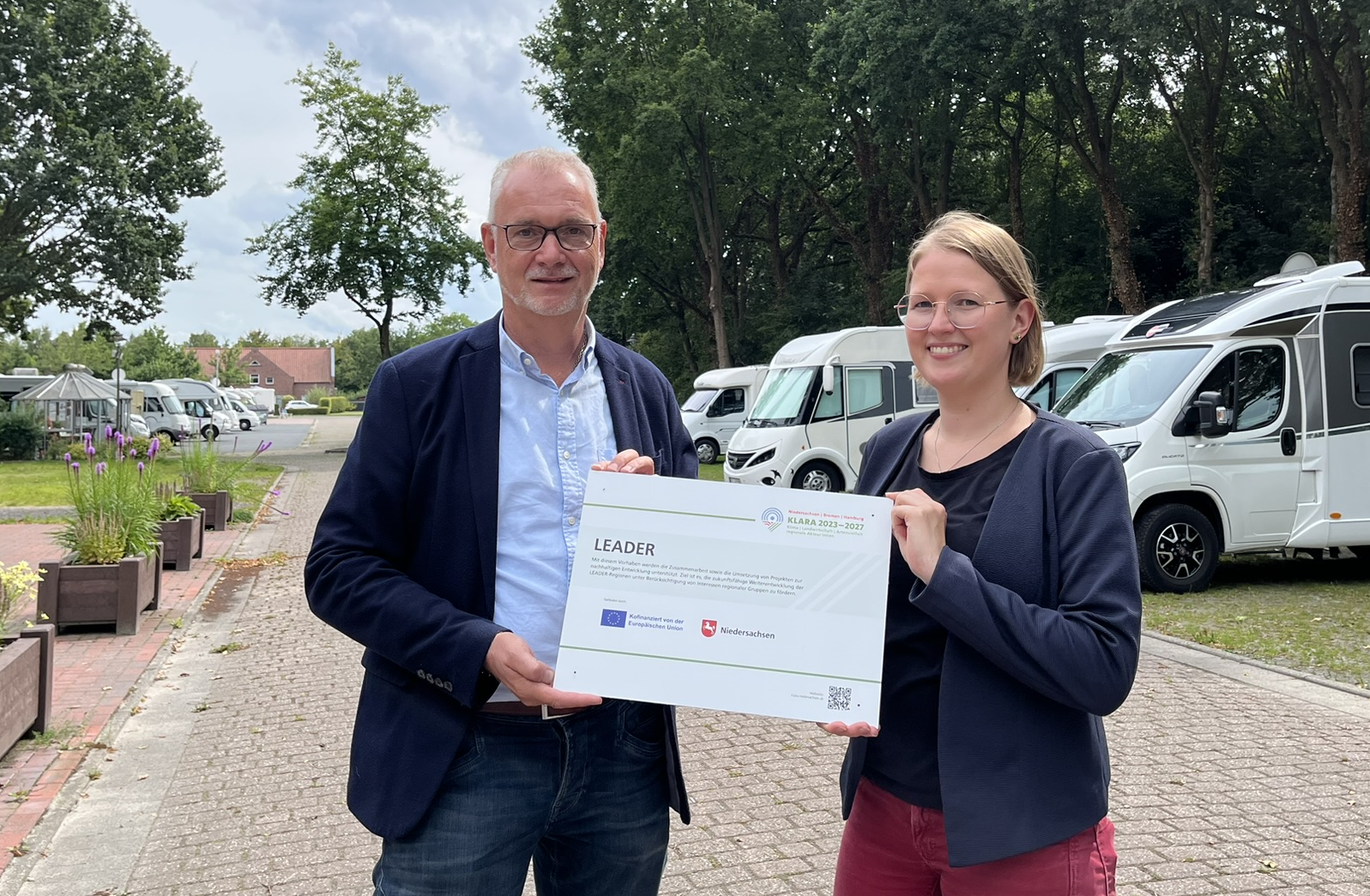 Daniela Kirschsstein, Regionalmanagerin LEADER-Region Fehngebiet, übergibt symbolisch den Bewilligungsbescheid an Bürgermeister Günter Harders