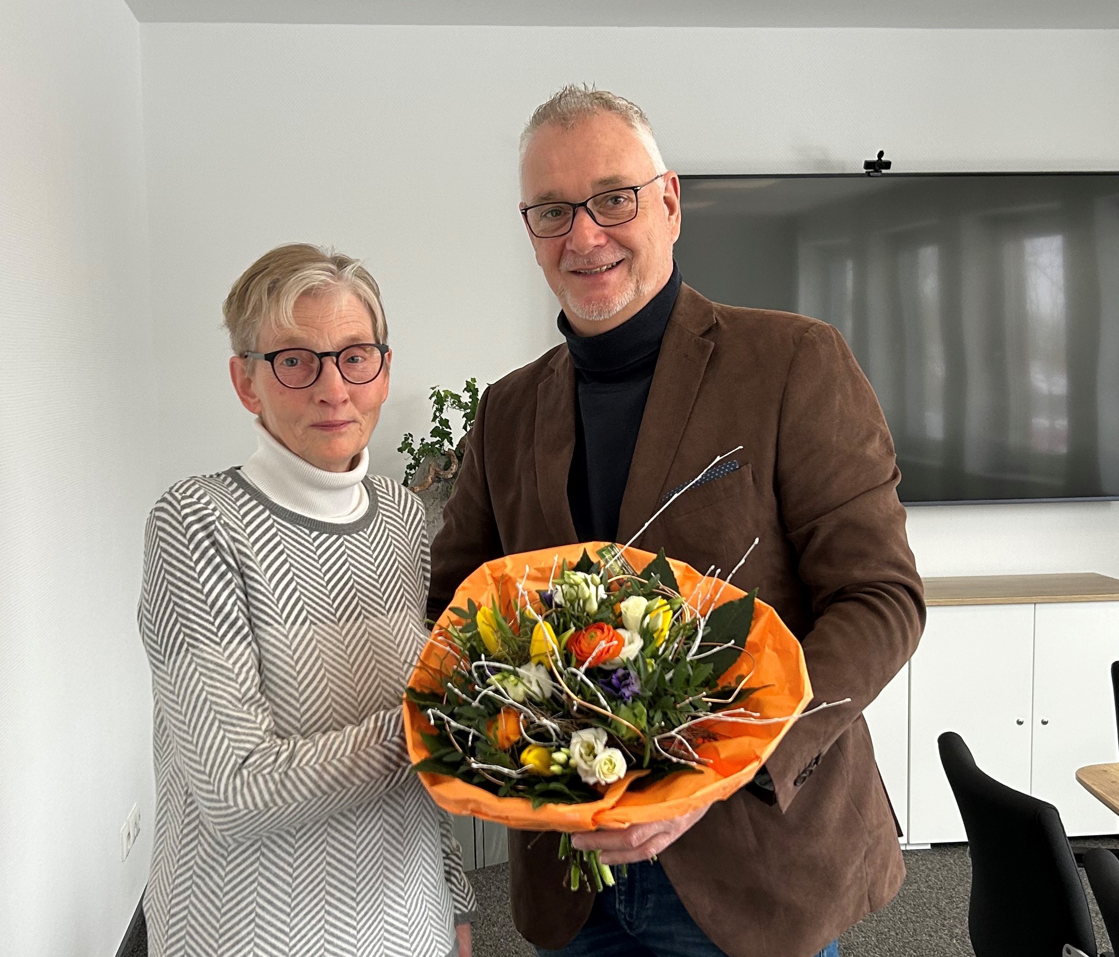 Bürgermeister Günter Harders überreicht Henny Brinkmann einen Blumenstrauß